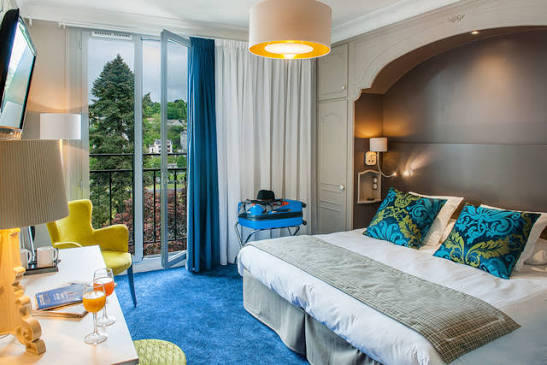 Guest room at the Grand Hôtel Gallia et Londres in Lourdes, with a balcony overlooking the gardens